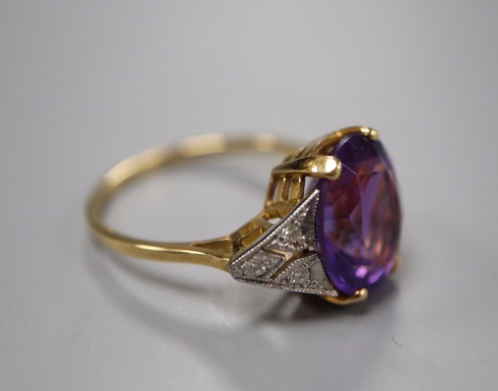 An Art Deco style yellow metal, amethyst and diamond seven-stone ring, the oval amethyst claw-set, size N, gross 3.7 grams.